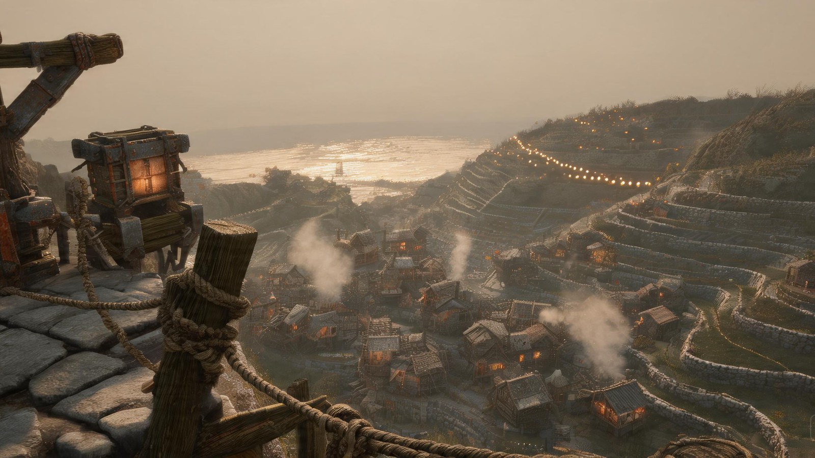 Lampfold from the Watch: terraced slopes falling toward a glinting sea, woodsmoke over the village bowl, a string of lamps climbing the far hill.
